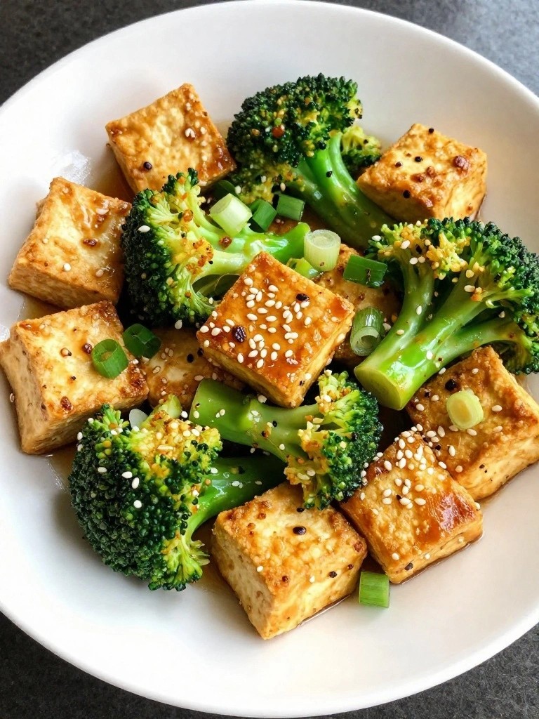 Crispy tofu cubes and broccoli florets in glossy sauce with sesame.