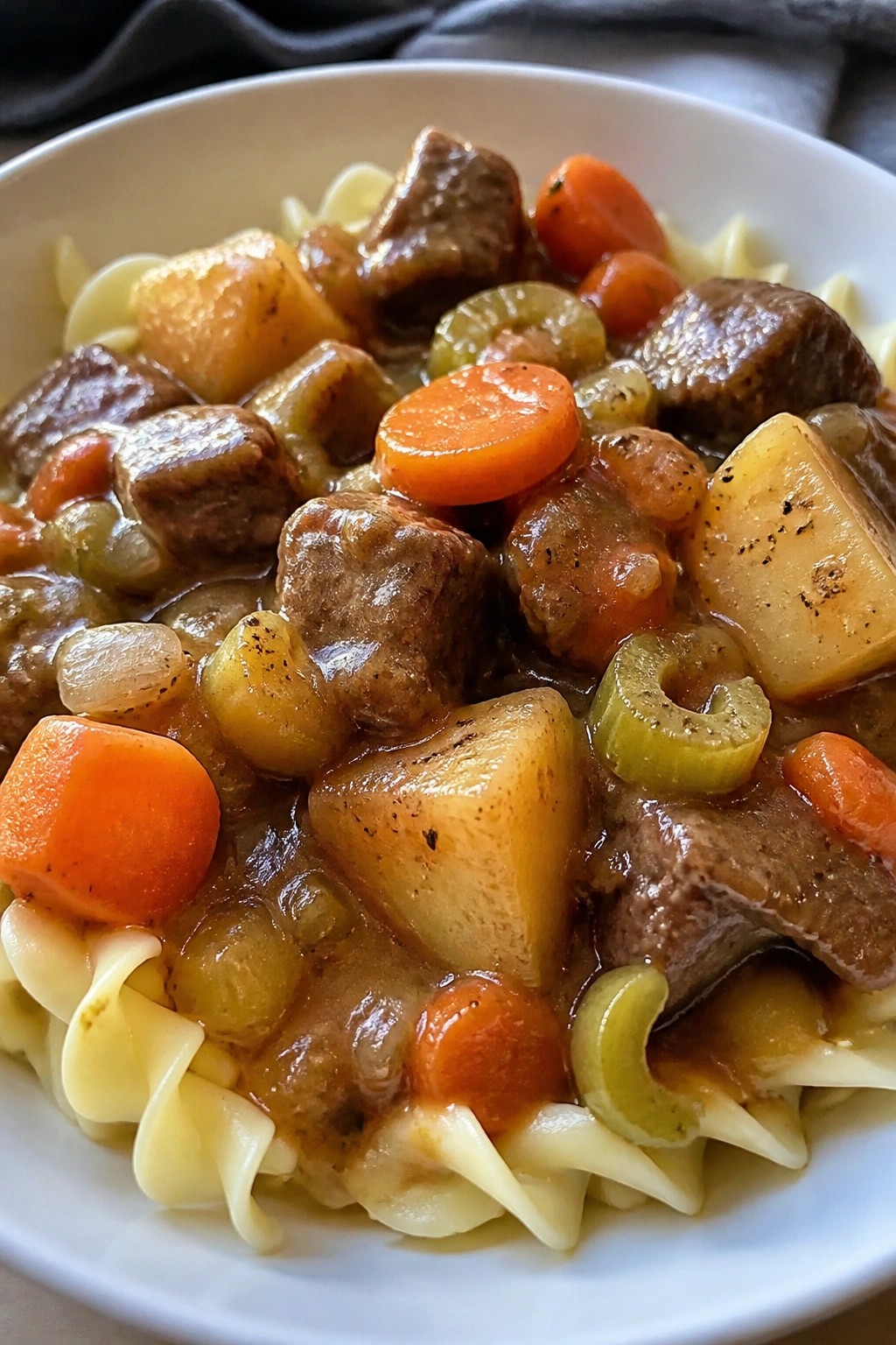 Hearty Beef Stew Served Over Buttered Egg Noodles