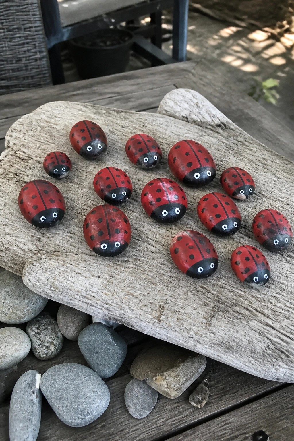 Hand-painted red ladybug rocks with spotted shells on weathered wood
