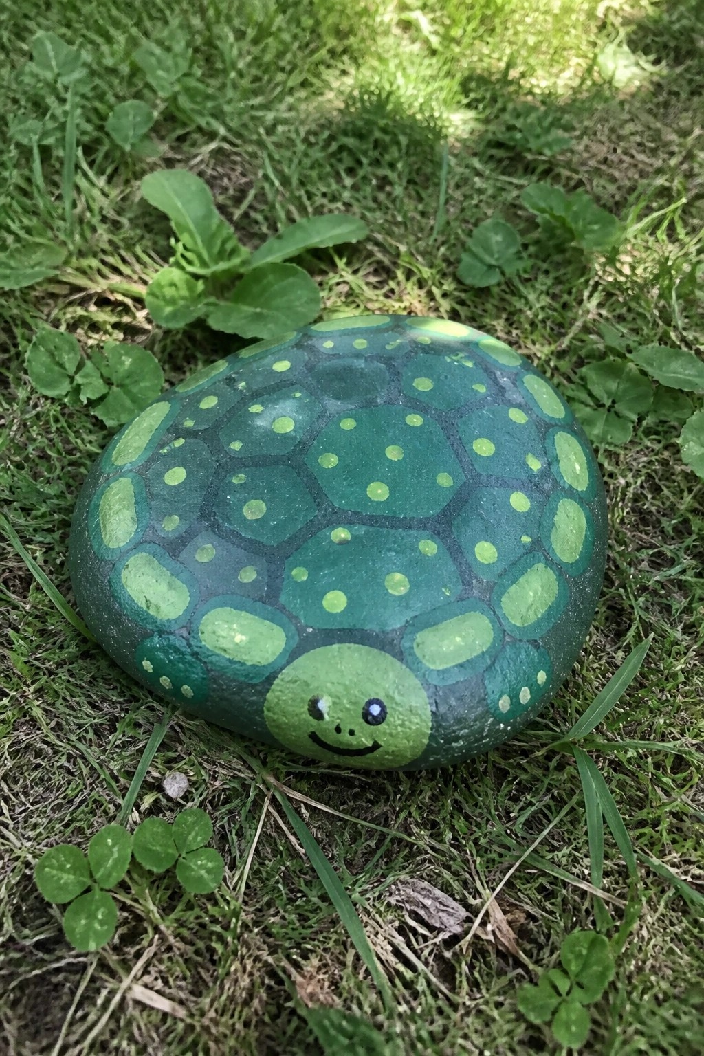 Green painted turtle rock with light green shell pattern on grass
