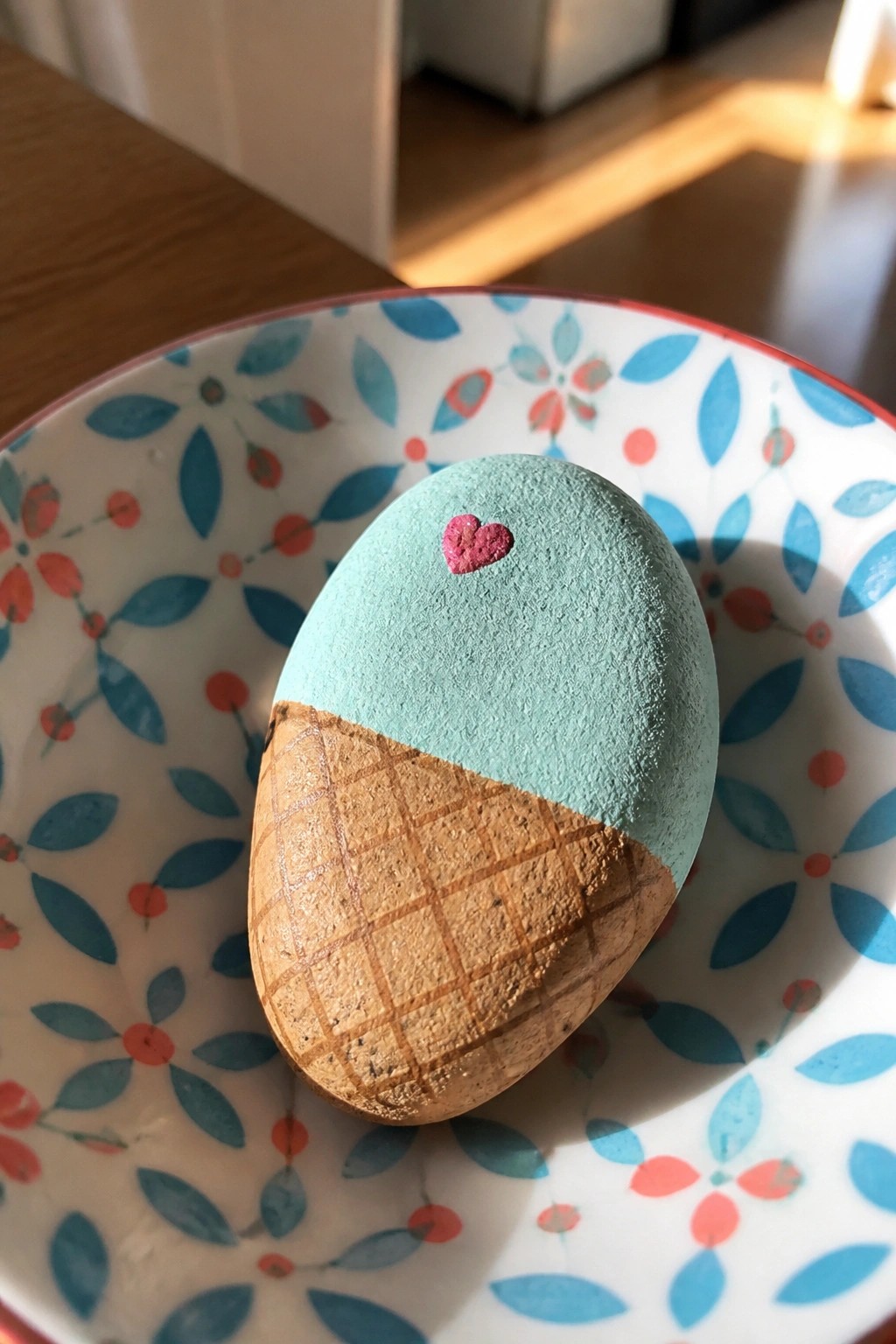 Painted egg as ice cream cone with pink heart in patterned bowl