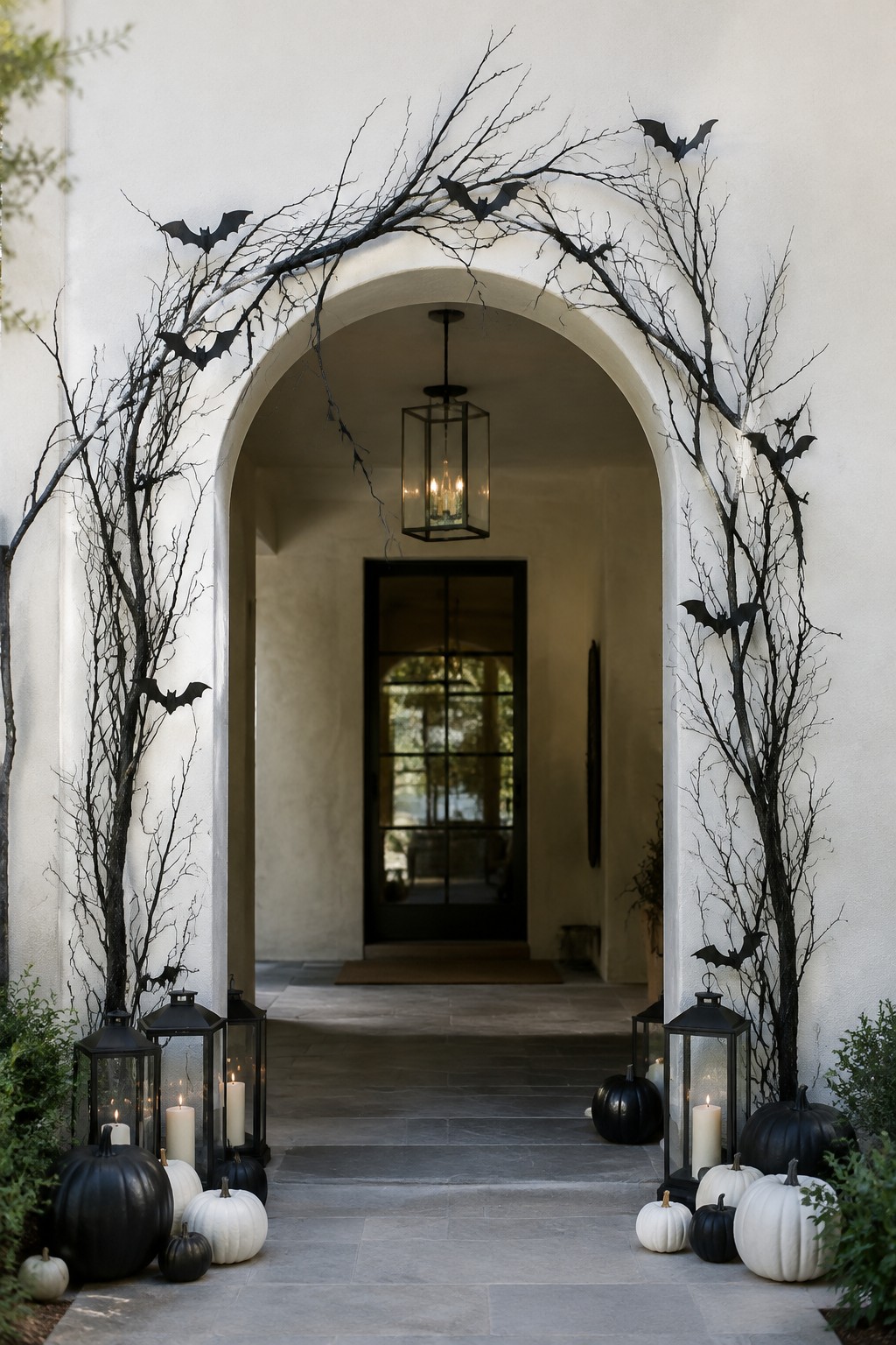 Halloween archway decorated with black branches, bats, pumpkins, and glowing lanterns.