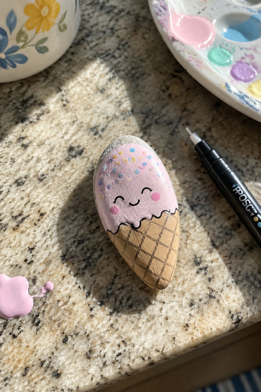 Painted rock as pink ice cream cone with sprinkles and cute smiling face